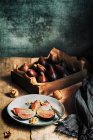 Figos frescos servidos em prato com nozes na mesa rústica — Fotografia de Stock