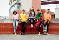 Подростки со скейтбордами на заборе — стоковое фото