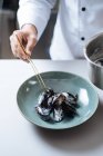 Крупным планом шеф-повара, подающего нордические блюда из морепродуктов с мидиями на тарелке — стоковое фото