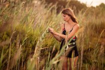 Mulher em roupa de verão em pé na grama campo — Fotografia de Stock