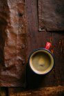 Enamel cup of coffee on rustic wooden surface — Stock Photo