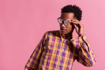 Stylish hipster man in sunglasses and shirt on pink background — Stock Photo