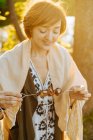 Молода жінка на пікніку пробує смачні страви з бекону на шампурі, що стоїть у яскравому сонячному світлі — стокове фото
