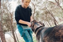 Grande cane marrone e proprietario femminile che gioca nella foresta — Foto stock