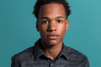 Retrato de jovem afro-americano sério homem na camisa no fundo azul — Fotografia de Stock
