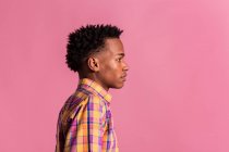 Hipster black man in colorful shirt standing on pink background — Stock Photo