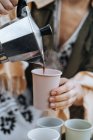 Самки руки розливу свіжозварену каву з кавоваркою у чашки на пікнік — стокове фото