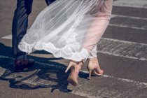Супруги в свадебной одежде держатся за руки — стоковое фото