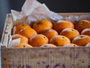 Gros plan des oranges mûres dans une boîte en bois — Photo de stock