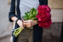 Gros plan de la femme tenant un bouquet de pivoines roses — Photo de stock