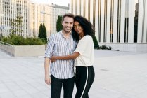 Romantic multiracial couple hugging on street together — Stock Photo