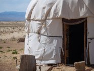 Extérieur de la tente traditionnelle nomade yurta sur la terre sèche du terrain — Photo de stock