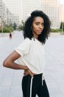 Смеющаяся афроамериканка, стоящая на улице и смотрящая в камеру — стоковое фото