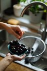 Людські руки тримають маленьку миску свіжого промитого винограду — стокове фото