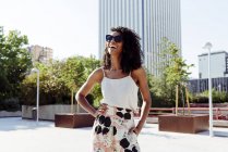 Elegante afrikanisch-amerikanische Frau lacht an einem sonnigen Tag auf der Straße der modernen Stadt — Stockfoto