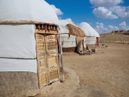 Exterior of traditional nomad tents yurtas on dry land of terrain, Uzbekistan — Stock Photo