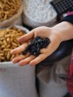 Fabric bags of dry fruits and hand with raisins — Stock Photo