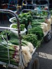 Bunches of fresh greens on trolley at farmer market — Stock Photo