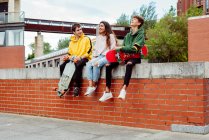 Підлітки зі скейтбордами на паркані — стокове фото