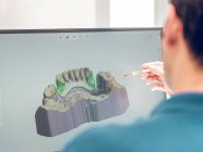Dentist modeling jaw on computer — Stock Photo