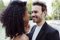 Charmantes multirassisches Paar, das sich im Freien umarmt und ansieht — Stockfoto