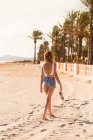 Mulher magra em roupas de verão passeando na praia tropical — Fotografia de Stock