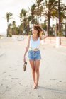 Mujer delgada en ropa de verano paseando por la playa tropical - foto de stock