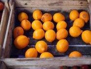 Limones frescos maduros en caja de madera - foto de stock