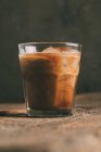 Льодяно-холодна кава в склянці на дерев'яній поверхні — стокове фото