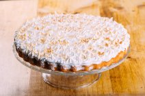 Хрусткий пиріг, увінчаний запеченим білим пухнастим злиттям на підставці для торта — стокове фото