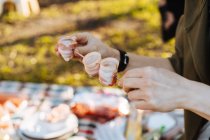 Mains humaines arrangeant des bandes de bacon pliées sur une brochette en métal pour le repas barbecue — Photo de stock