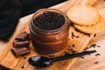 Dessert alla mousse con cioccolato in barattolo su tavola di legno — Foto stock