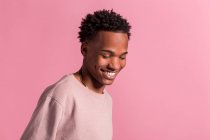 Улыбающийся хипстер черный мужчина позирует на розовом фоне — стоковое фото