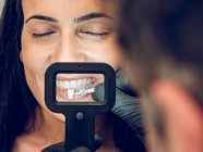 Dentista recogiendo el color de la prótesis dental - foto de stock