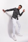 Hombre joven afroamericano de moda en denim blanco y camisa de pie sobre fondo blanco en postura - foto de stock