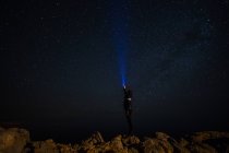 Mann zündet den Mann an, der nachts eine Taschenlampe zu den Sternen wirft — Stockfoto