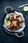 Baking dish of baked chicken wings in sesame and parsley with lemon — Stock Photo