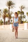 Slim donna in abiti estivi passeggiando sulla spiaggia tropicale — Foto stock