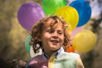 Retrato de niño preescolar con globos de colores - foto de stock
