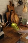 Женская рука держит свежую зеленую кучу сельдерея на деревянном столе — стоковое фото