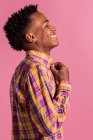 Rindo hipster homem negro em camisa colorida no fundo rosa — Fotografia de Stock