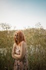 Giovane donna bionda posa in erba alta sulla riva del lago — Foto stock