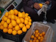 Продавець і витирання лимонів на фермерському ринку — стокове фото