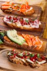 Assortiment de sandwichs nutritifs différents sur planche de bois — Photo de stock