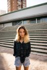 Bionda giovane donna in piedi davanti alle scale sulla strada — Foto stock