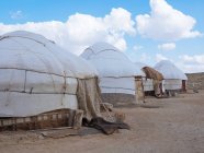 Exterior de las tiendas nómadas tradicionales yurtas en tierra firme de terreno, Uzbekistán - foto de stock