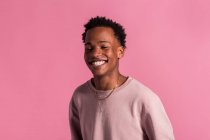 Smiling hipster black man posing on pink background — Stock Photo