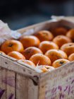Крупным планом спелых апельсинов в деревянной коробке — стоковое фото