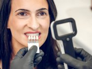 Zahnarzt pflückt Farbe der Prothese — Stockfoto