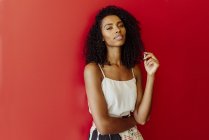 Portrait of sensual African-American woman standing on red background — Stock Photo
